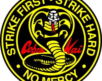 May include: Circular emblem with a black background and a yellow border. The emblem features a yellow cobra with a red tongue and the words "Strike First, Strike Hard, No Mercy" in yellow. The words "Cobra Kai" are in red.