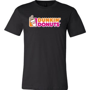 May include: Black t-shirt featuring the Dunkin' Donuts logo. The logo includes a coffee cup and the words "DUNKIN' DONUTS" in orange and pink. The shirt is a short-sleeved crew neck.