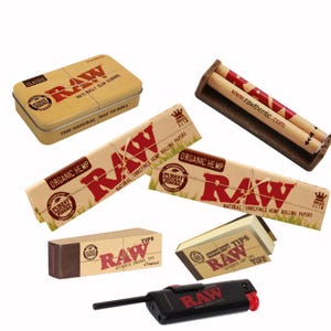 May include: An assortment of RAW brand smoking accessories, including a metal tin, rolling papers, a rolling machine, and tips. The products feature the RAW logo in red on a natural brown background. A black lighter with a red button is also included.