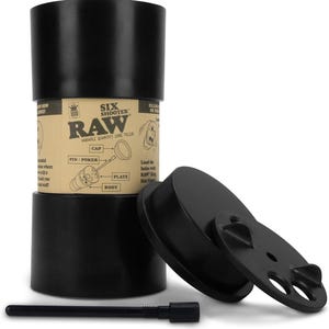 May include: Black RAW Six Shooter cone filler with a cap, plate, and pin/poker. The product has a cylindrical shape with a label that includes instructions and diagrams. The product is designed for filling cones.