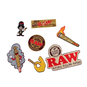 May include: A collection of embroidered patches featuring the word "RAW" in red and white. The patches include a cartoon character, a lit joint, a hand gesture, and a pack of rolling papers. The patches are in various shapes and sizes.