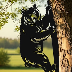 Könnte beinhalten: Schwarzer Bär, der einen Baum erklimmt, mit detailliertem Design. Der Bär hat eine hellfarbige Kontur und ist vor einem natürlichen Hintergrund aus grünem Gras und Bäumen platziert. Der Bär ist ein dekorativer Gegenstand.
