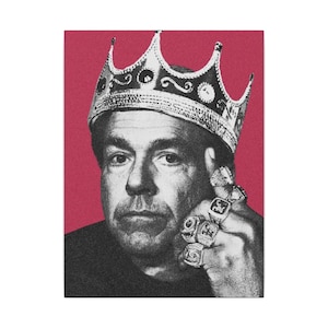 May include: Black and white portrait of a man wearing a silver crown and multiple rings. The background is a solid red color. The man is looking directly at the viewer.
