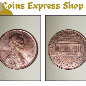 以下が含まれることがあります： 2つの銅色の米国の1セント硬貨。片面にはエイブラハム・リンカーンと1992年が描かれています。もう片面にはリンカーン記念館と「One Cent」の文字が描かれています。「Coins Express Shop」というショップ名が上部にあります。