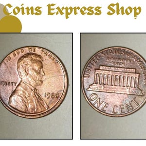 Può includere: Due penny americani color rame, uno con il profilo di Abraham Lincoln e l'anno 1980, l'altro con il Lincoln Memorial. Il testo "Coins Express Shop" è in alto.