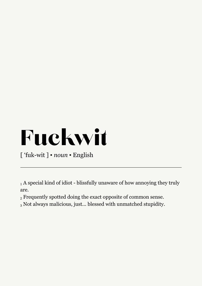 Op de afbeelding: Een minimalistische print op een cr&egrave;mekleurige achtergrond met het woord "Fuckwit" in vette zwarte letters. De definitie van het woord staat eronder. Het ontwerp is in het Engels.