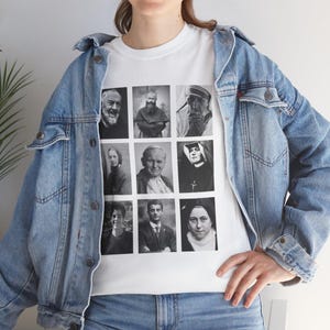 Puede incluir: Camiseta blanca con una cuadrícula de retratos en blanco y negro de figuras religiosas. La camiseta se usa con una chaqueta vaquera azul claro y vaqueros azules. Los retratos incluyen santos y líderes religiosos.