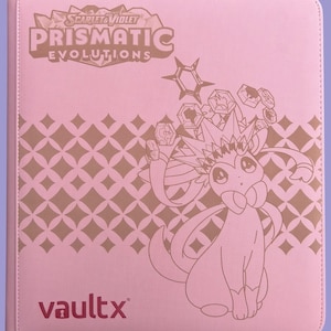 May include: Pink card binder with the text "Scarlet & Violet Prismatic Evolutions" and a cartoon illustration. The binder has a repeating diamond pattern and the "vaultx" logo.
