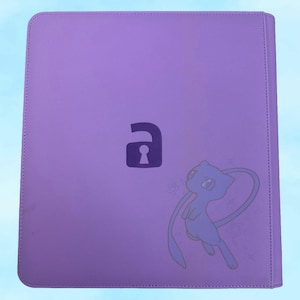 May include: A purple binder with a keyhole graphic and a cartoon character illustration. The binder has a stitched border and a light blue background.