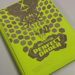 May include: A neon green card binder with a brown graphic of a creature and the words "MEGA EVOLUTION PERFECT ORDER". The binder has a honeycomb pattern and the word "vaultx" embossed on the bottom.