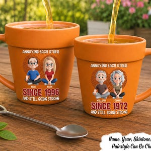 May include: Two orange terracotta-style ceramic mugs with handles, each featuring a cartoon illustration of a couple, the text "ANNOYING EACH OTHER SINCE [YEAR] AND STILL GOING STRONG," and names "NICK AND NOAH" or "WILLIAM AND JENNIE" printed on the front.