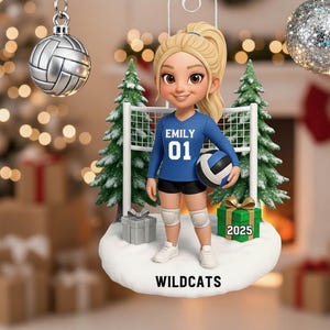 May include: A hanging Christmas ornament featuring a blonde volleyball player in a blue jersey with the name EMILY and number 01, holding a volleyball. The figure stands on a snowy base labeled WILDCATS with a green gift box marked 2025.