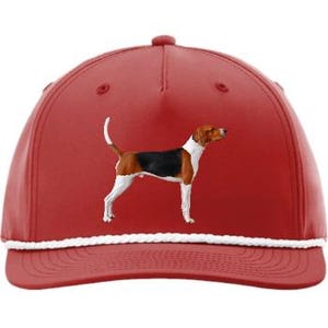 May include: A red baseball cap with a white rope brim and a detailed illustration of a dog. The dog is primarily white, black, and brown. The cap has a curved brim and a button on top.