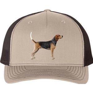 May include: Tan and brown trucker hat featuring a detailed illustration of a Bloodhound dog. The hat has a mesh back and a curved brim. The dog is depicted in a realistic style, with a black, brown, and tan coat.