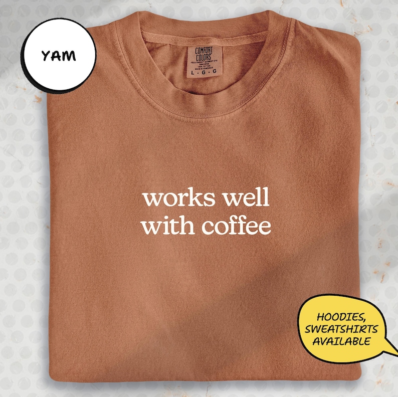 a brown t-shirt with the text "works well with coffee" printed on it.