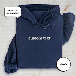 A navy blue hoodie with the text "custom text" printed on it, along with a speech bubble indicating that the hoodie is available for custom text.