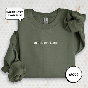 A green sweatshirt with the text "custom text" printed on it, along with a speech bubble indicating that the sweatshirt is available for purchase.