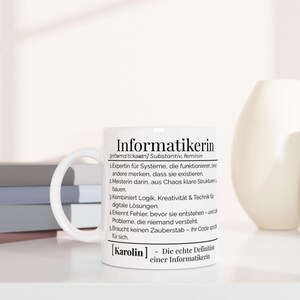 Könnte beinhalten: Weiße Keramik-Tasse mit dem Wort "Informatikerin" und einer Definition in schwarzer Schrift. Die Tasse hat einen weißen Henkel und steht auf einer weißen Oberfläche.