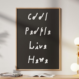 May include: A framed black chalkboard with the words "Cool People Live Here" in white script. The wooden frame surrounds the chalkboard. The board is displayed above a wooden cabinet with decorative items.