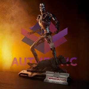 May include: A metallic Terminator figure with a detailed skeletal design, standing on a rocky base. The figure has red eyes and is posed in a dynamic stance. The base features a plaque with "THE TERMINATOR" text.