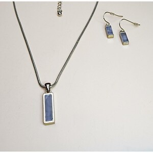 Rechthoekige hanger met edelsteen in een zetting, verguld met slangenketting en bijpassende oorbellen.