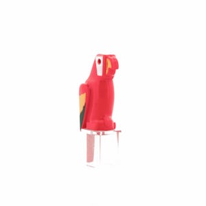 Op de afbeelding: Een rode plastic papegaaienfiguur met witte, gele en groene accenten. De papegaai staat op een heldere, vierkante basis. De vogel heeft een witte kop, een gele snavel en een kleurrijke vleugel.