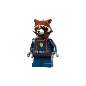 Puede incluir: Una minifigura de Lego de Rocket Raccoon. La figura tiene una cabeza de mapache marrón con marcas blancas, que lleva un uniforme azul con detalles en rojo y un emblema dorado. La figura tiene manos grises y está de pie sobre una base azul.