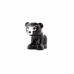 Könnte beinhalten: Eine schwarze Bärenfigur mit weißem Gesicht und braunen Augen. Der Bär sitzt mit sichtbaren Vorderpfoten. Die Figur ist aus Kunststoff und hat eine glänzende Oberfläche.