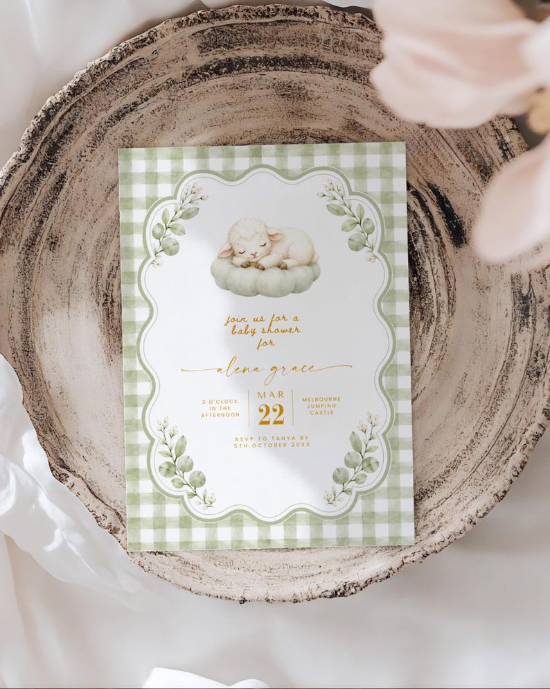 May include: A rectangular baby shower invitation card featuring a green and white gingham border, a central illustration of a sleeping lamb on a cushion, and gold text reading Join us for a baby shower for Alena Grace, March 22, 8 o'clock in the afternoon.