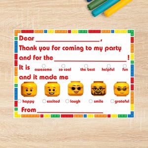 Pode incluir: Cartão de agradecimento de festa com tema Lego, com uma borda de blocos coloridos. O cartão tem prompts para preencher, com rostos em estilo Lego representando diferentes emoções. O texto é claro.