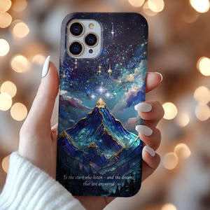 May include: A smartphone case featuring a dark blue and purple night sky filled with stars above a stylised mountain range with gold accents. The text at the bottom reads: To the stars who listen - and the dreams that are answered.