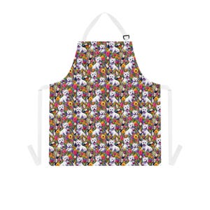 May include: White apron featuring a repeating pattern of white dogs, wine bottles, and colourful flowers. The apron has a white neck strap and waist ties, and a black clasp. The design includes sunflowers, roses, and other floral elements.