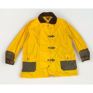 Puede incluir: Chaqueta amarilla brillante con cuello de pana marrón y parches de ante marrón en los bolsillos y puños. La chaqueta tiene cuatro cierres de palanca y dos bolsillos delanteros. Prenda de abrigo clásica.