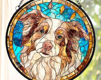 May include: Round stained glass window featuring a dog's face. The dog has brown and white fur, with blue and yellow accents in the background. The window is framed in black and hangs from a chain.