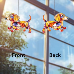 May include: Two stained glass dachshund ornaments, one labeled "Front" and the other "Back". The dogs are in a running pose, with colorful patchwork designs in shades of yellow, orange, red, purple, and blue. Each ornament hangs from a silver chain.