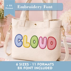 Puede incluir: Un bolso de lona color crema con dos asas y una correa de hombro desmontable. El frente presenta la palabra CLOUD en letras grandes de tela colorida y estampada. Un botón de presión dorado está centrado en la abertura superior.