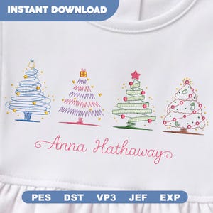 May include: A white fabric surface featuring an embroidery design of four stylized Christmas trees in blue, purple, green, and pink, accented with small shapes. Below the trees, the name Anna Hathaway is embroidered in pink cursive script.