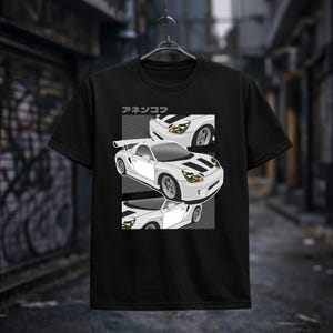 May include: Black t-shirt featuring a white sports car graphic with black stripes and the Japanese text "アネケンコフ". The car design is repeated in three sections. The shirt is hanging on a black hanger.