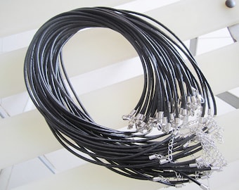 May include: A bundle of black leather cords with silver clasps. The cords are arranged in a circle and are ready to be used for jewelry making.