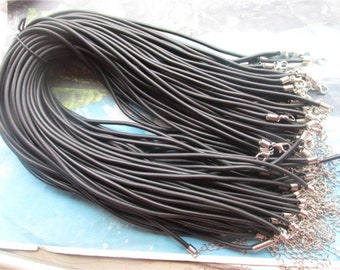 May include: A bulk pack of black elastic cord, approximately 100 pieces, with silver metal clasps attached to each cord.