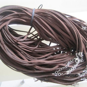 Könnte beinhalten: Ein großes Bündel braunes Wildlederband, ca. 200 Stück, mit silberfarbenen Karabinerhaken und Sprungringen.