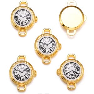 Puede incluir: Encantos de esfera de reloj dorados con esferas blancas y números romanos negros. Las esferas tienen un diseño clásico con manecillas negras y un lazo en la parte superior e inferior para sujetar. Los amuletos son redondos y tienen un bisel dorado.