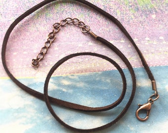 Peut inclure: Un collier en cordon de cuir marron avec une chaîne et un fermoir en bronze.