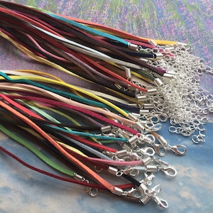 May include: A collection of colourful suede cords with silver clasps. The cords are arranged in a fan shape and are ready to be used for jewellery making.