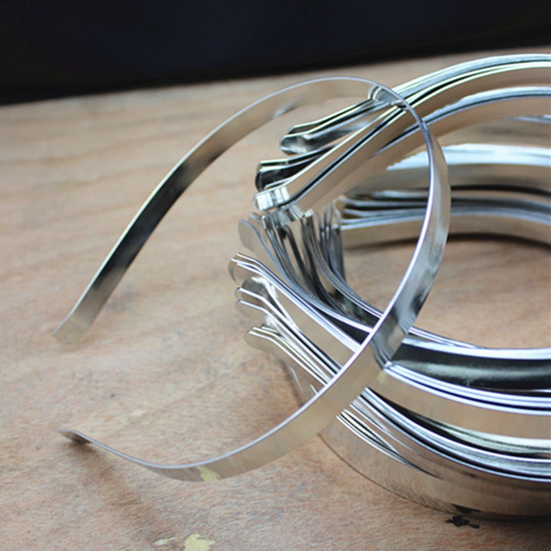 May include: A stack of silver metal headbands. The headbands are thin and flexible, and they are perfect for adding a touch of sparkle to any outfit.