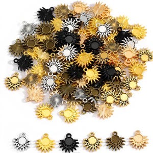 Può includere: Una collezione di ciondoli a forma di sole in varie finiture metalliche, tra cui oro, argento, bronzo e nero. Ogni ciondolo presenta un cerchio centrale e raggi radianti, perfetti per la creazione di gioielli.