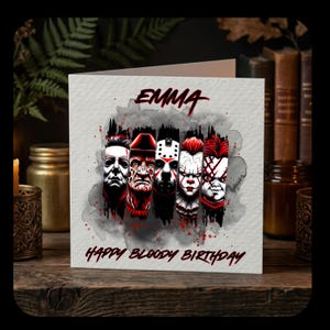 May include: A square greeting card featuring the name EMMA at the top and the text HAPPY BLOODY BIRTHDAY at the bottom. The centre displays a watercolour-style illustration of five horror movie characters in black, white, and red tones.