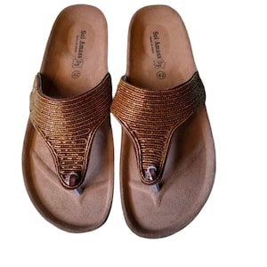 May include: A pair of brown sandals with a thong-style design. The sandals have a cork footbed and a metallic gold strap. The brand name "Sol Amass" is visible on the footbed. Size 42.