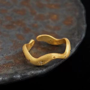 Gouden verstelbare ring sterrengolf - mat onregelmatige gouden band met mini-stergravures en micro-edelstenen hemels golvende gouden ring