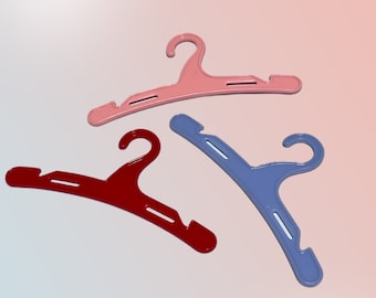 May include: Three plastic hangers in different colors: pink, red, and blue. The hangers are designed for hanging clothes.